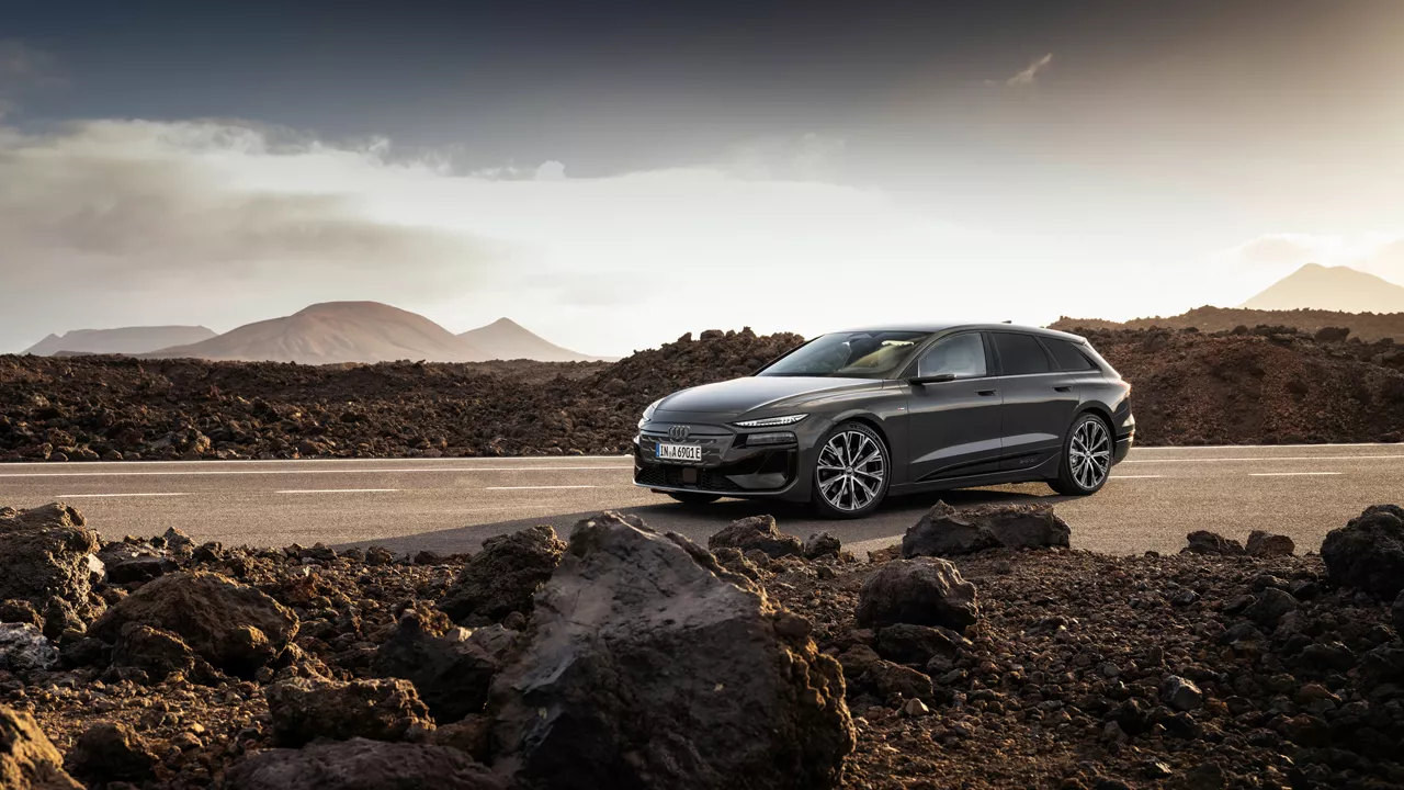 Audi A6 Avant e-tron performance stands on a road against a mountain backdrop. There are stones and rubble next to the road.